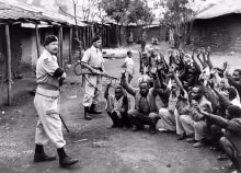 British Soldiers keep guard on detainees in 1954.